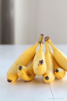 a bunch of ripe bananas sitting on top of a white table next to each other