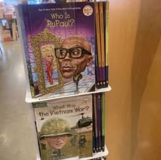 a book shelf with books and pencils on it in a store or bookstore room