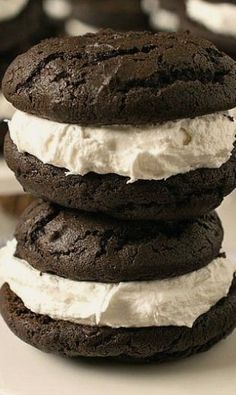 three chocolate cookies stacked on top of each other with whipped cream in between the cookies