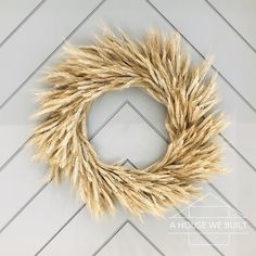 a wreath made out of dried grass sitting on top of a wall