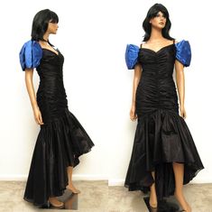 "This is a gorgeous vintage prom dress from the 1980s.  The main body of the dress is made out of a sheer black chiffon, and it is fully lined in black acetate.  The upper part of the dress has a fitted wiggle cut with a ruched design and mild boning for support.  The skirt of the dress is made out of a full circle of material, and there is an attached layer of netting underneath to help show off the fullness, creating the mermaid look.  The dress has short cap sleeves made out of blue satin.  The sleeves fall off the shoulder, and there are little straps that go over the shoulder area.  The dress is longer in the back than in the front, creating a dramatic asymmetric hem.  It closes with a zipper down the back. The tag labels this a size 9/10.  However, the dress looks like it was profess 80s Mermaid, Mom Prom, 80s Dress Vintage, 1980 Dress, Retro Prom, Hi Low Gown, 1980s Prom, Sketchbook Practice, Mermaid Look