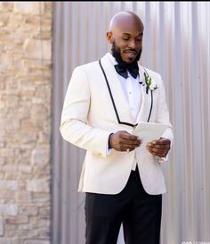 a man in a tuxedo looking at his tablet