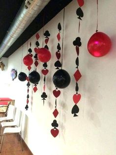 the wall is decorated with red and black playing cards, hearts, and balloons hanging from strings