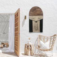 an outdoor area with a chair, table and wall hanging on the side of it