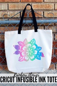 a tote bag hanging on a fence with the words cricut infusible ink