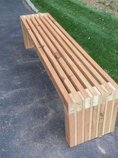 a wooden bench sitting on the side of a road