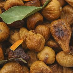 closeup of nuts with leaves on top and dried fruit in the bottom right corner