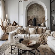 a living room filled with white furniture and lots of pillows on top of it's couches