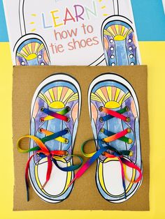 a pair of shoes with colorful ribbons tied around them on top of a cardboard box