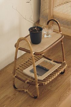 a small table with a magazine rack on it and a potted plant next to it