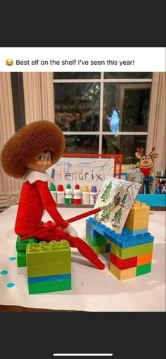 an elf is sitting on top of legos with the caption best elf on the shelf i've seen this year