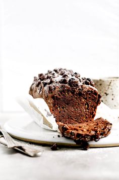 a piece of chocolate cake sitting on top of a white plate next to a cup