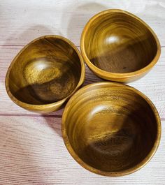 three wooden bowls sitting on top of a table