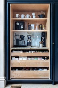 an open cabinet filled with lots of coffee and tea items on top of wooden shelves