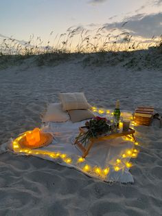 a blanket on the beach with lights around it