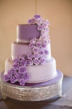 a three tiered cake with purple flowers on it