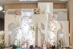 an elaborately decorated stage set up for a wedding ceremony with flowers on the wall