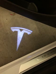 a close up of a logo on the side of a car door with it's light reflecting off