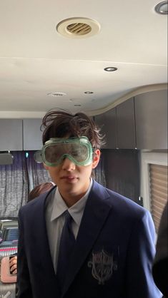 a man in a suit and tie wearing goggles