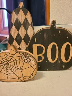 three wooden halloween decorations sitting on top of a counter