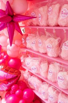 pink and white balloons are on display in a store with star shaped balloons hanging from the ceiling