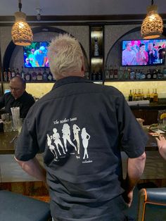 a man sitting at a bar watching tv