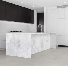 a white kitchen with black cabinets and an island