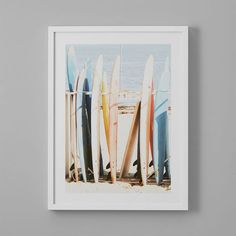 a group of surfboards sitting on top of a white wall next to each other