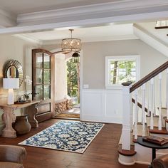 an instagramted photo of a living room with stairs and rugs on the floor