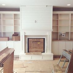 an instagramted photo of a fireplace in the middle of a room with built - in shelving