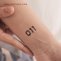 a person with a tattoo on their arm that reads 011 and has the number eleven printed on it