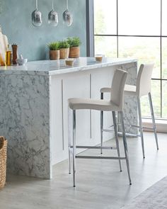 a kitchen with marble counter tops and bar stools