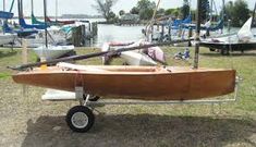 a small wooden boat is parked on the grass