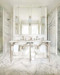 a marble bathroom with double sinks and mirrors