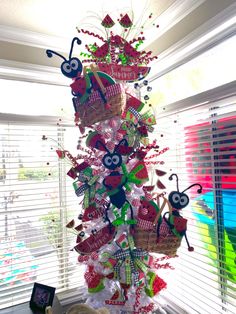 a christmas tree made out of plastic bags and other items in front of a window