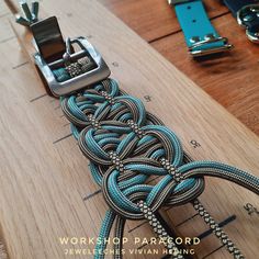 a wooden table topped with lots of different types of cords and buckles on it