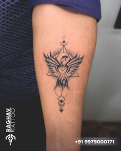 a tattoo on the leg of a woman with an eagle and triangle design in black ink