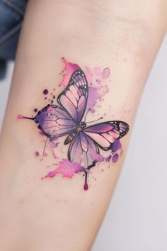 a pink and purple butterfly tattoo on the left arm, with watercolor splashes all over it