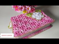 a pink crocheted book with flowers on it