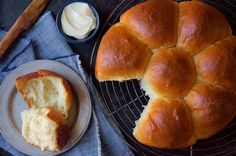 a loaf of bread sitting on top of a cooling rack next to a bowl of butter