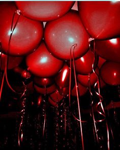 many red balloons are floating in the air