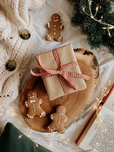 an open book on top of a wooden plate next to christmas decorations and gingerbreads