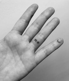 a person's hand with the word me tattooed on it, in black and white