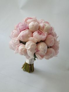 a bouquet of pink flowers sitting on top of a white table