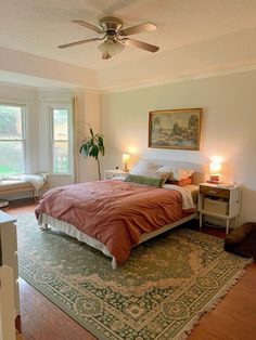 a bedroom with a bed, rug and ceiling fan