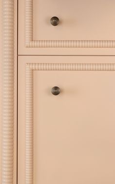 a white dresser with two drawers and knobs