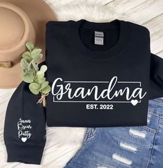 "This super cute and trendy grandma sweatshirt would be perfect for  Mother's Day, Christmas or even a Birthday!  She will be able to lounge in comfort and style.  Will feature Grandma with and \"Est. Date\" below in the middle of the sweatshirt and feature all of her grandchildren's names on the sleeve with a cute little heart below the names.  Please list Grandkid's names in order you would like them to be listed from top to bottom! ♥ UNISEX CREWNECK SWEATSHIRT ♥ You will need to add each sweater individually to your cart and go through the personalization process for each to specify your required notes for each :)     ♥ HOW TO ORDER ♥ 1. Make selections from the required drop down menus 2. Leave ALL details/information needed to complete your order in the personalization box at checkout Grandma Shirt Ideas Vinyl, Grandma Shirt Ideas Grandchildren Names, Grandma Established Shirt, Cute Sweatshirts Cricut, Cricut Gift Ideas For Grandma, Grandma Sweatshirt Ideas, Grandma Sweatshirts With Grandkids Names, Grandma Tshirts Ideas, Grandma Shirt Ideas