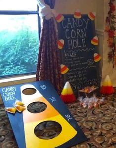 candy corn hole game set up in front of a window with candy cones on the floor