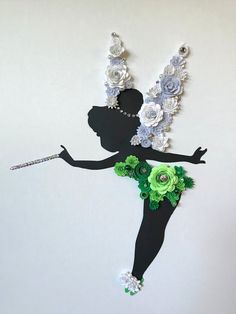 a paper cut out of a woman with flowers on her head and holding a cane