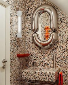 a bathroom with a sink, mirror and toilet paper dispenser in it